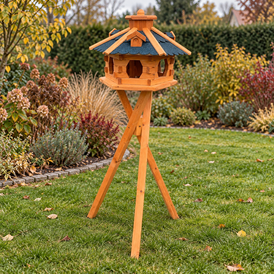 Vogelhaus 4 mit blauem Dach und Dreibeinständer im herbstlichen Garten