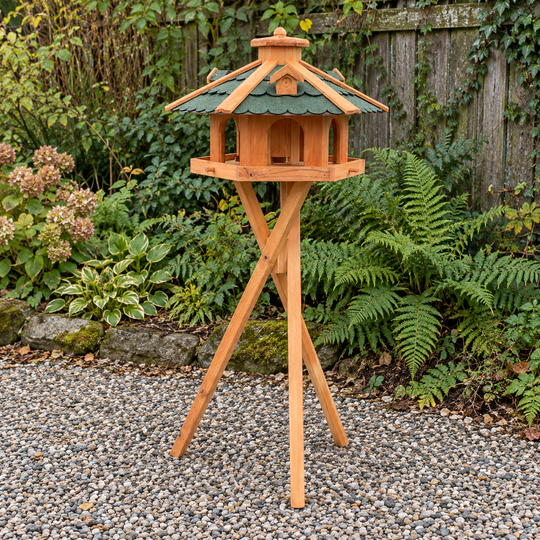 Sechseckiges Vogelfutterhaus mit grünem Bitumendach – mit Dreibeinständer im Garten